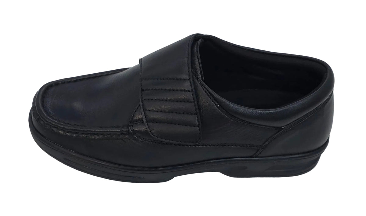 Black Dr Keller shoe with a broad hook-and-loop strap and stitched rounded toe